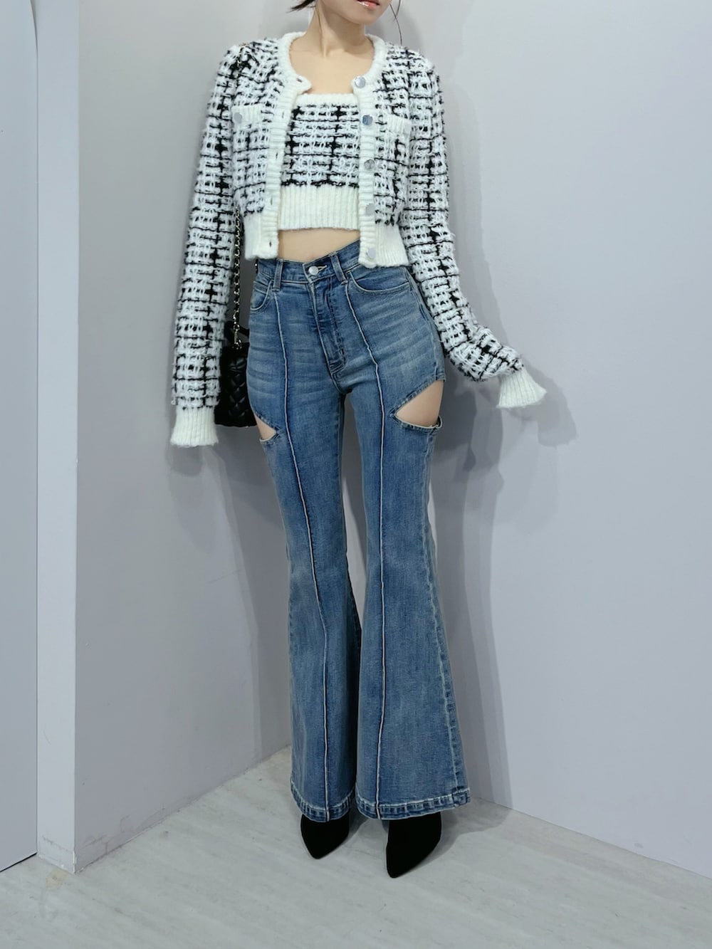 ブルー系のデニムパンツ、ホワイト系のニット/セーター、ブラック系のブーツを着用したレディースの秋コーディネートの6枚目の写真