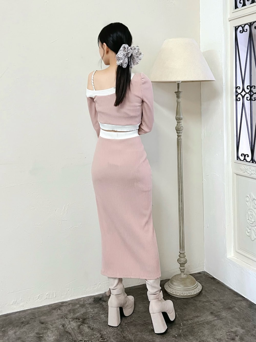 ピンク系のスカート、ピンク系のTシャツ/カットソー、ホワイト系のブーツを着用したレディースの冬コーディネートの3枚目の写真