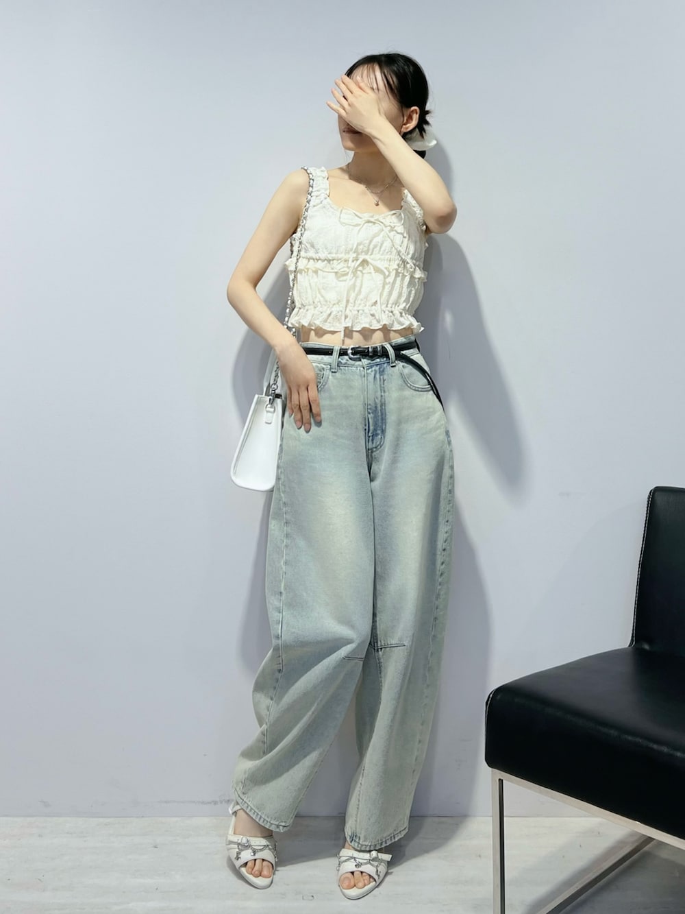 ブルー系のデニムパンツ、ホワイト系のサンダル、ホワイト系のキャミソールを着用したレディースの夏コーディネートの3枚目の写真