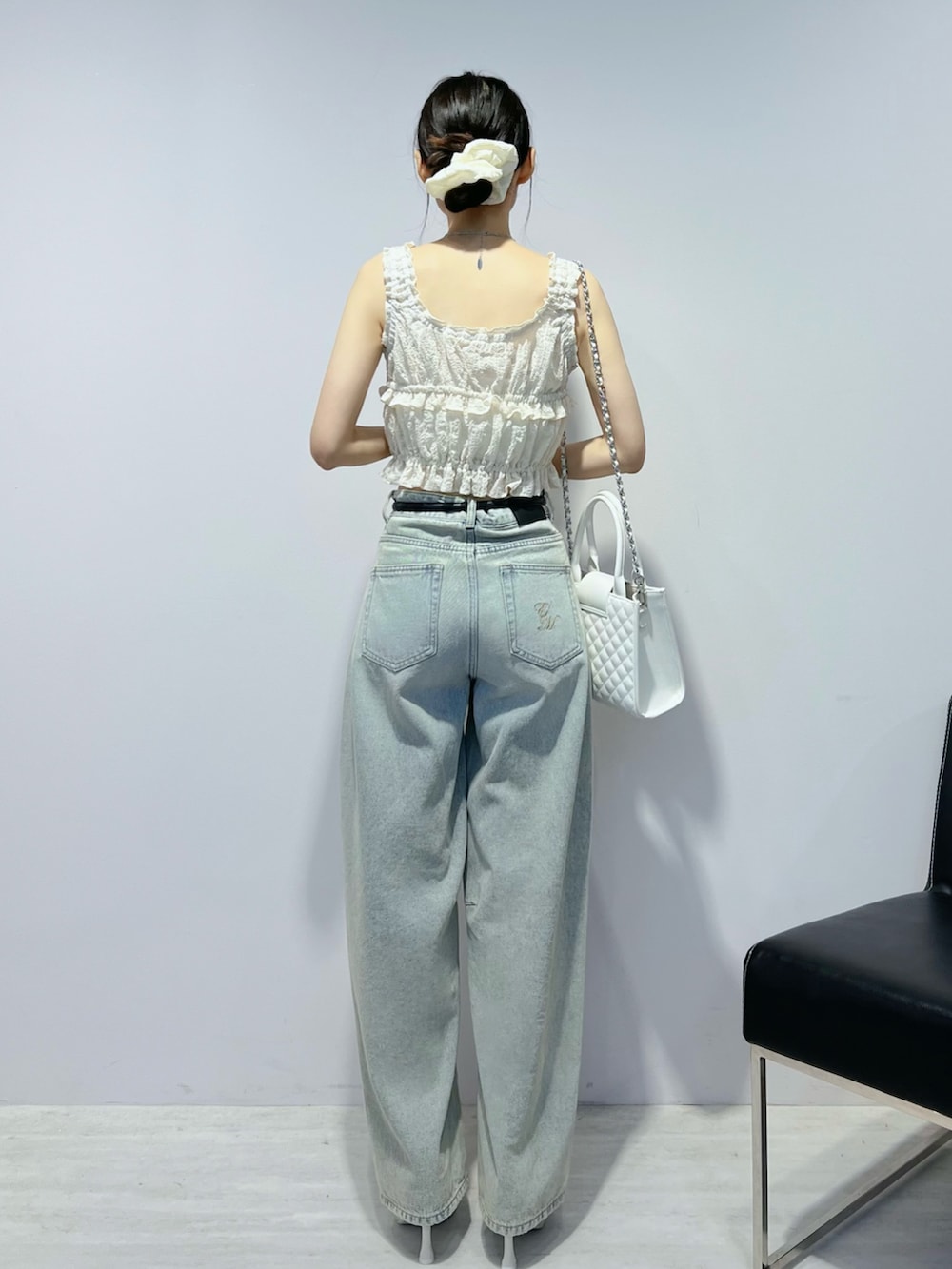 ブルー系のデニムパンツ、ホワイト系のサンダル、ホワイト系のキャミソールを着用したレディースの夏コーディネートの5枚目の写真