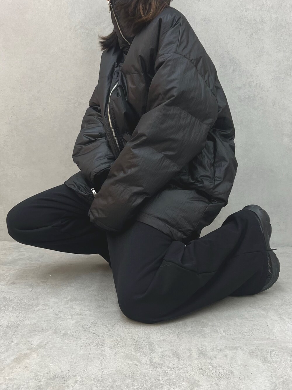 ブラック系のブルゾン、ブラック系のその他パンツ、ブラック系のTシャツ/カットソーを着用したレディースの冬コーディネートの9枚目の写真