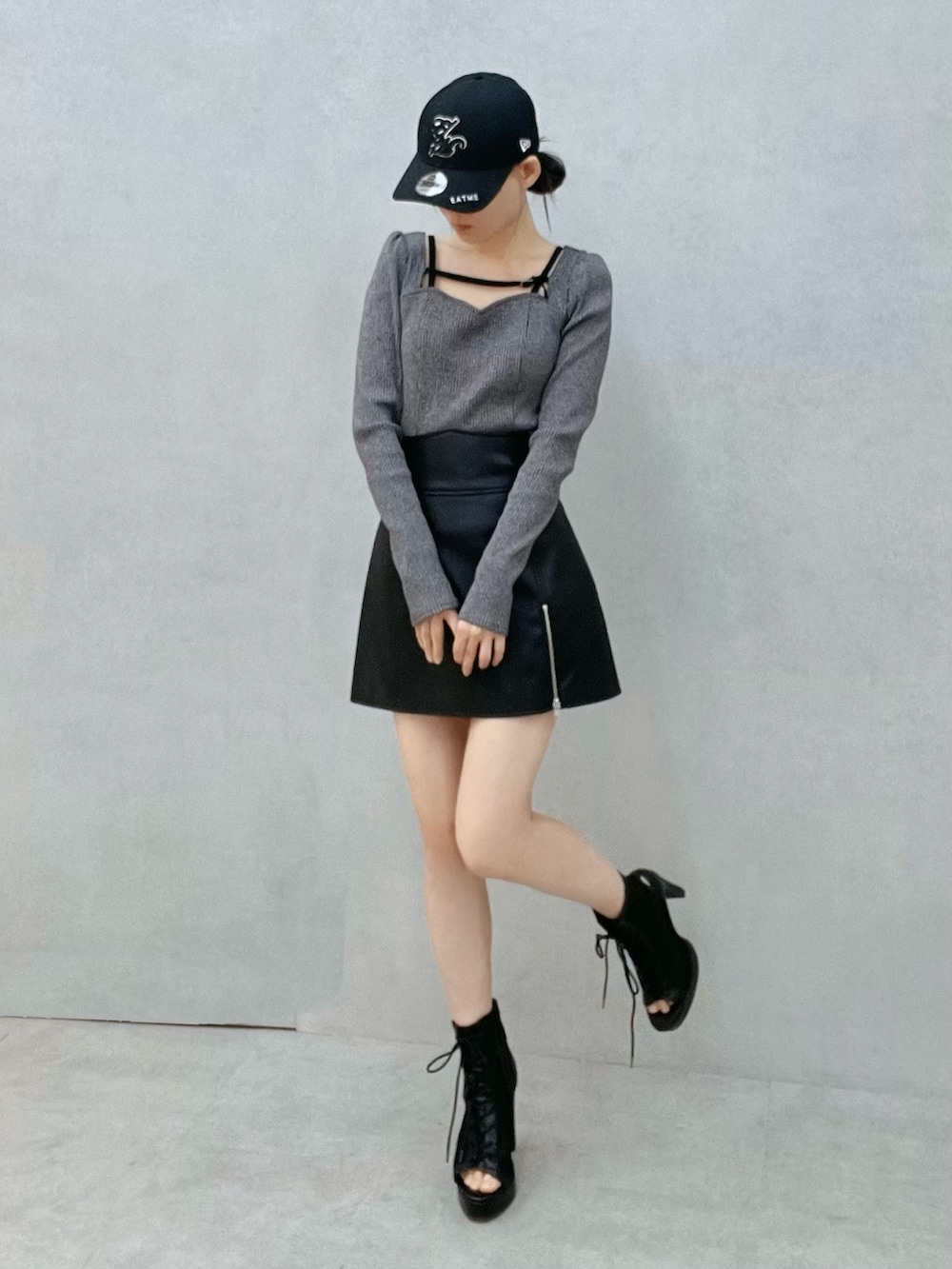 グレー系のTシャツ/カットソー、ブラック系のスカート、ブラック系のブーツを着用したレディースの冬コーディネートの5枚目の写真