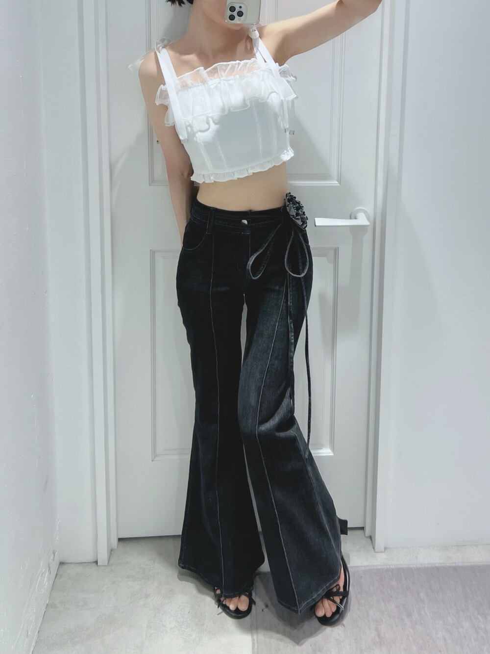 ブラック系のデニムパンツ、ブラック系のサンダル、ホワイト系のキャミソールを着用したレディースの春コーディネートの7枚目の写真