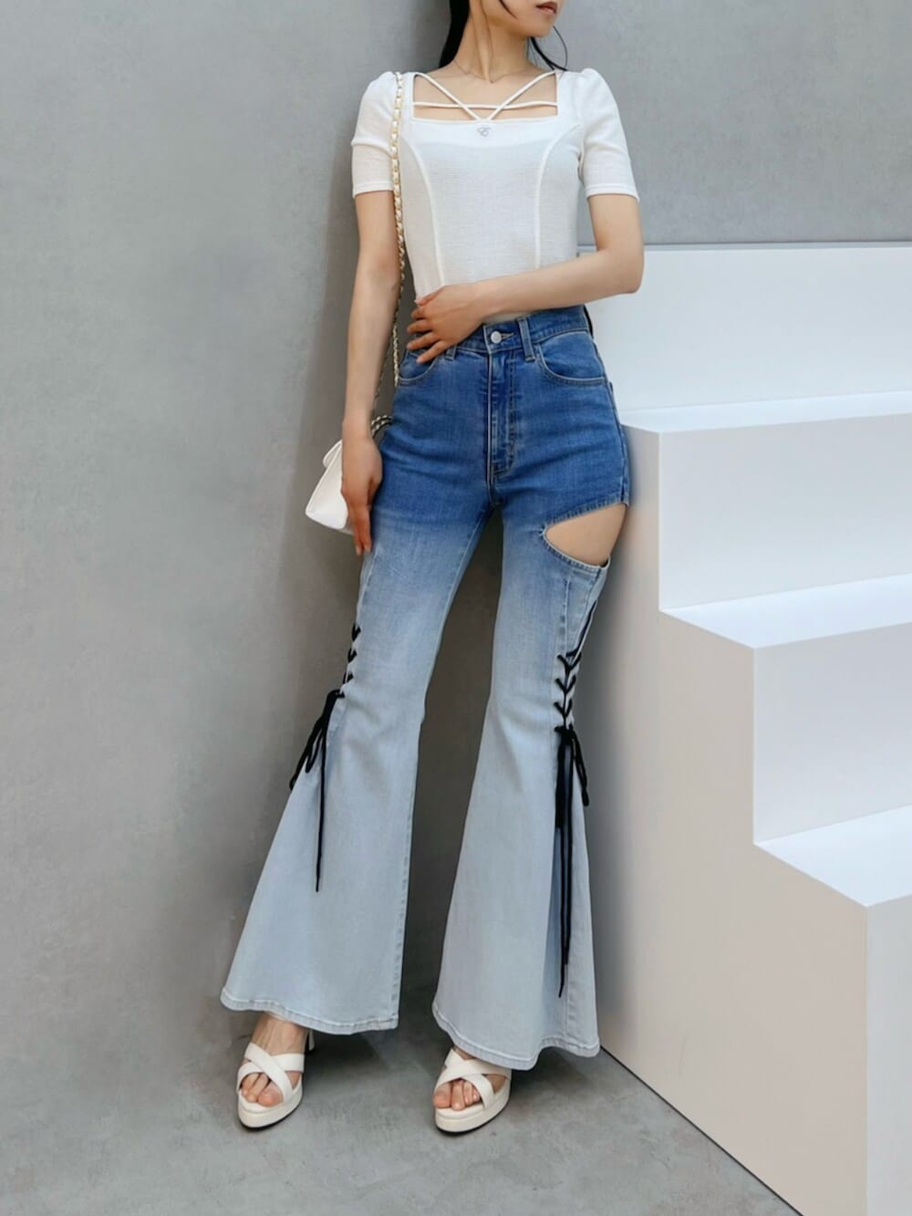 ホワイト系のハンドバッグ、ホワイト系のサンダル、その他のデニムパンツを着用したレディースの夏コーディネートの4枚目の写真