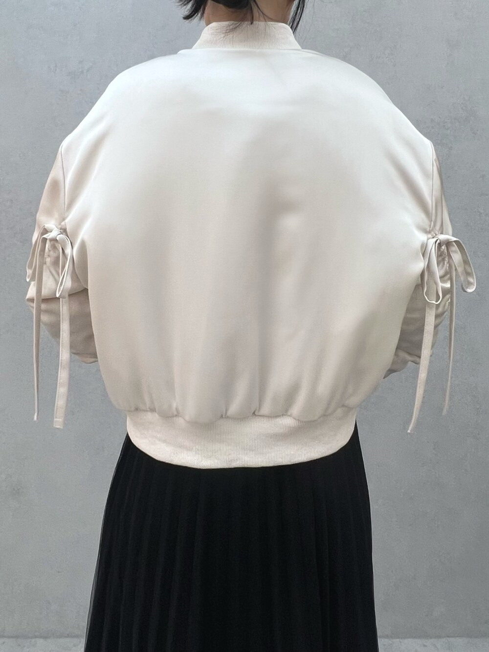 ホワイト系のニット/セーター、ホワイト系のブルゾンを着用したレディースの冬コーディネートの3枚目の写真