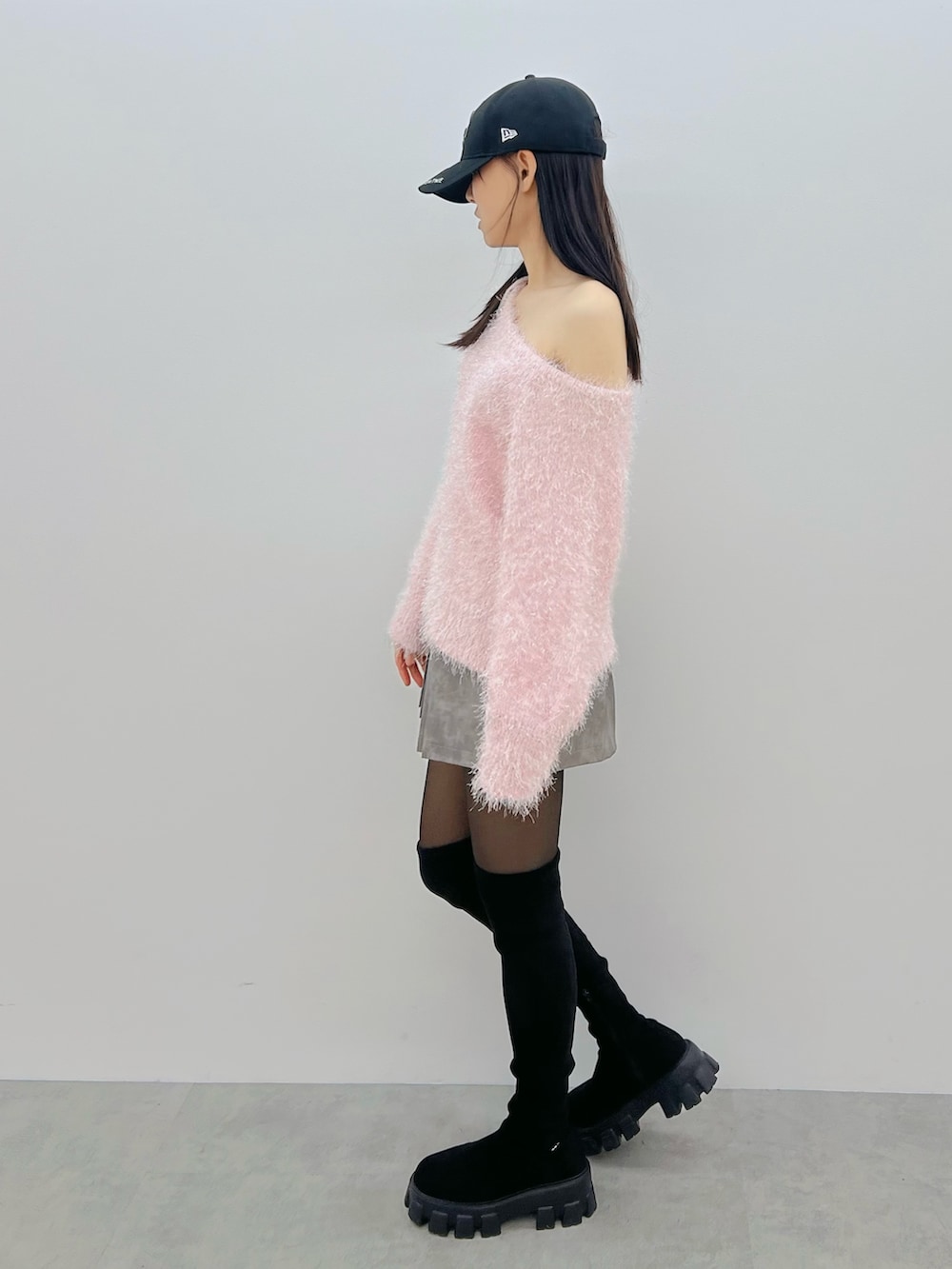 グレー系のスカート、ブラック系のブーツ、ピンク系のニット/セーターを着用したレディースの冬コーディネートの3枚目の写真