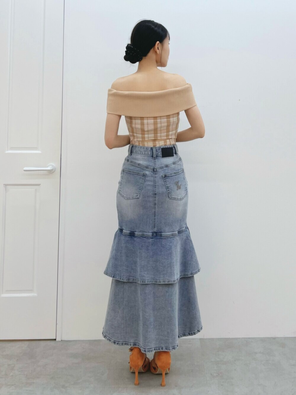 オレンジ系のワンピース、オレンジ系のサンダル、ブルー系のデニムスカートを着用したレディースの夏コーディネートの4枚目の写真