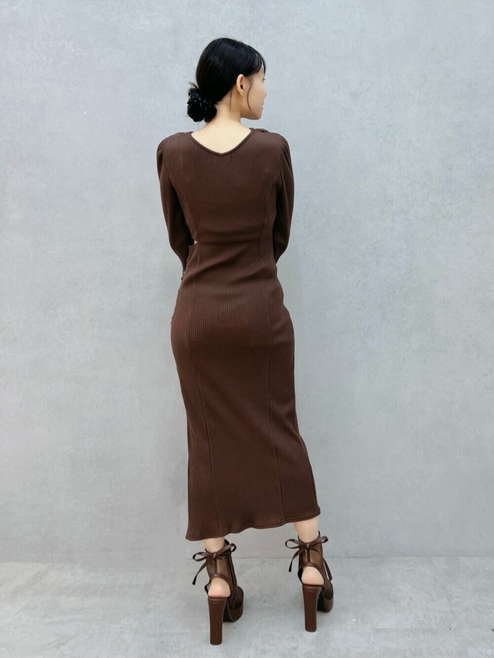 ブラウン系のサンダル、ブラック系のワンピースを着用したレディースの秋コーディネートの3枚目の写真