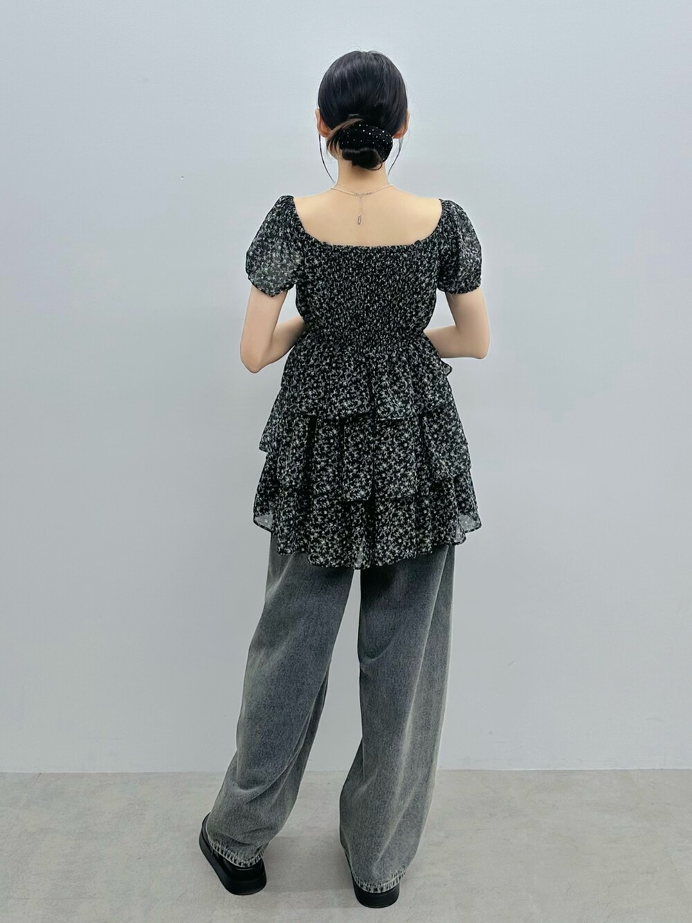 ブラック系のワンピース、ブルー系のデニムパンツ、シルバー系のネックレスを着用したレディースの夏コーディネートの4枚目の写真