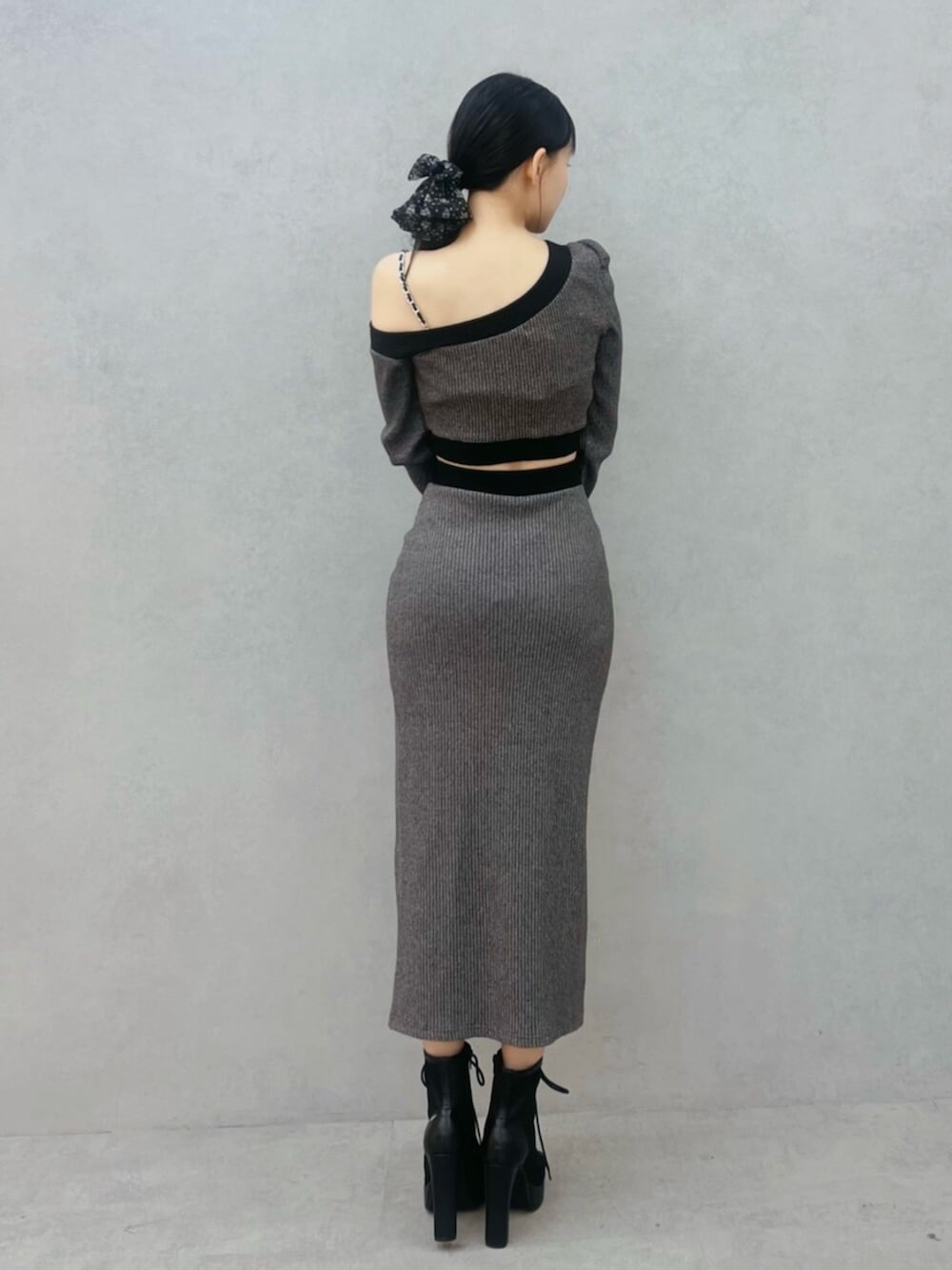 ブラック系のブーツ、グレー系のスカート、グレー系のTシャツ/カットソーを着用したレディースの冬コーディネートの3枚目の写真