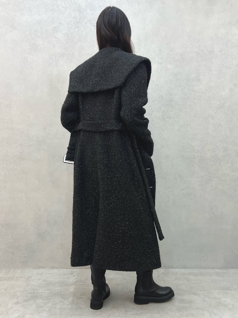 ブラック系のチェスターコート、レッド系のショルダーバッグ、ホワイト系のニット/セーターを着用したレディースの冬コーディネートの7枚目の写真