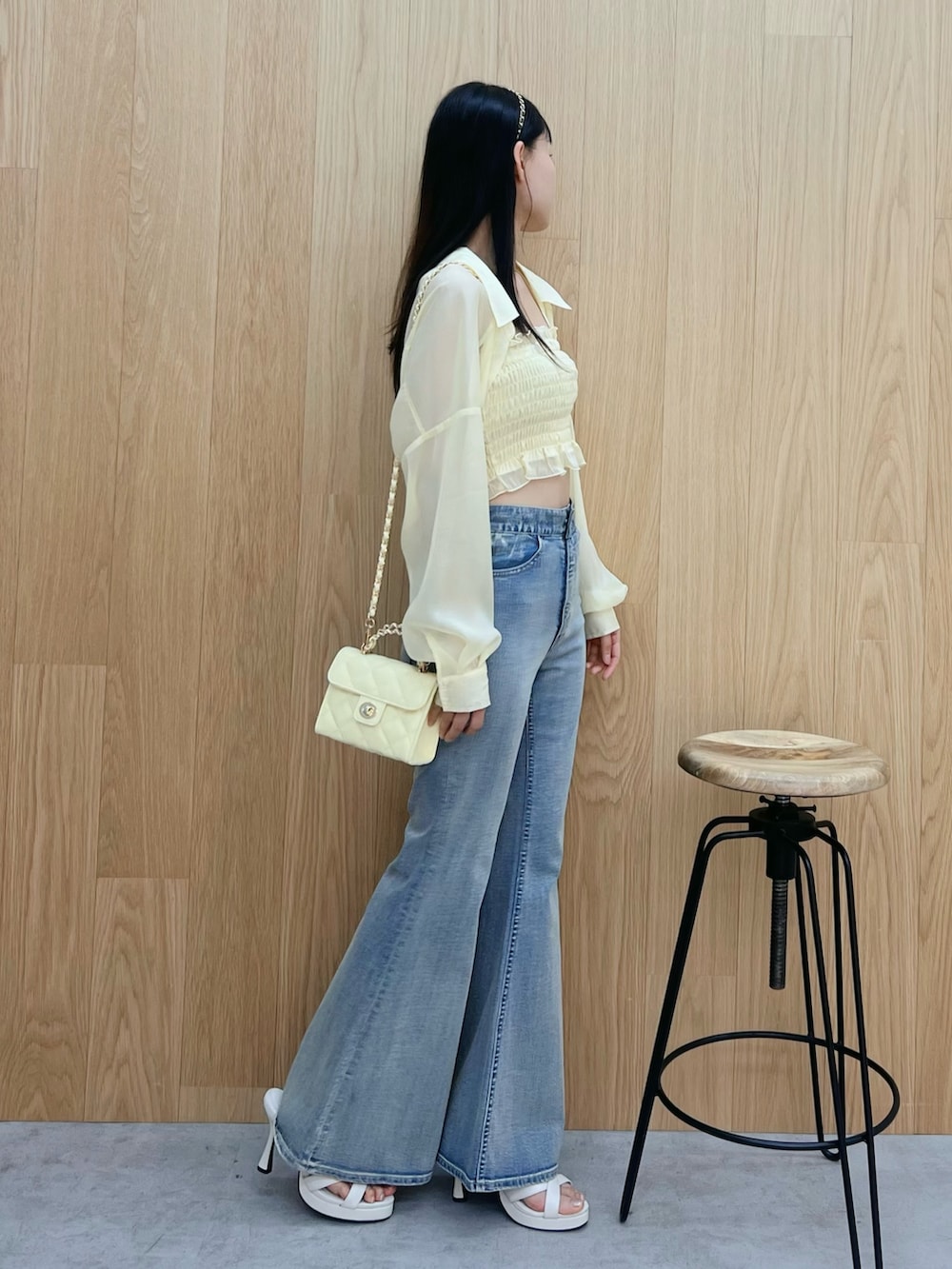 ホワイト系のサンダル、ブルー系のデニムパンツ、イエロー系のハンドバッグを着用したレディースの春コーディネートの2枚目の写真