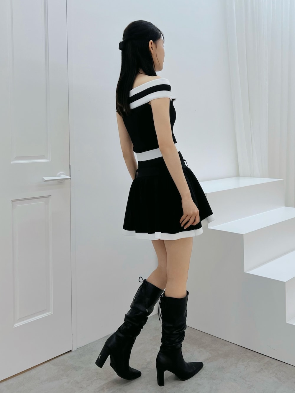 ブラック系のワンピース、その他のブーツを着用したレディースの秋コーディネートの2枚目の写真