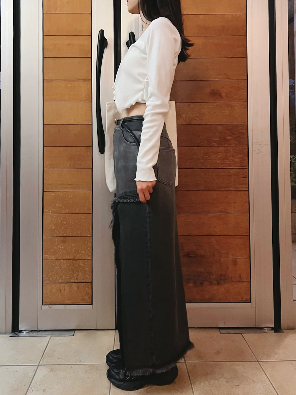 ブラック系のデニムスカート、ホワイト系のTシャツ/カットソーを着用したレディースの夏コーディネートの4枚目の写真