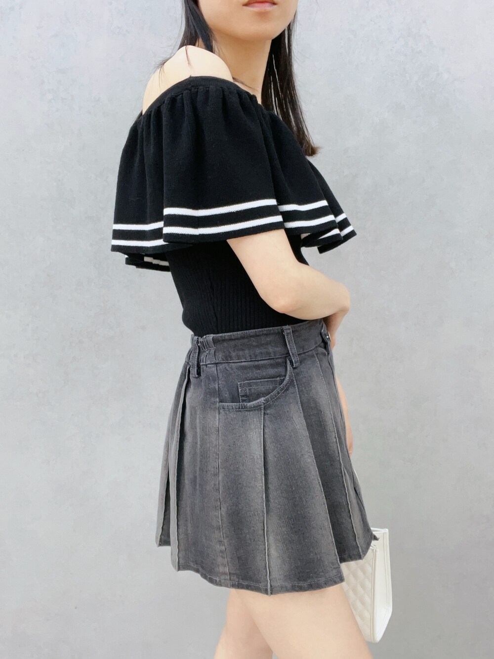 ブラック系のデニムスカート、ブラック系のサンダル、ホワイト系のハンドバッグを着用したレディースの夏コーディネートの8枚目の写真