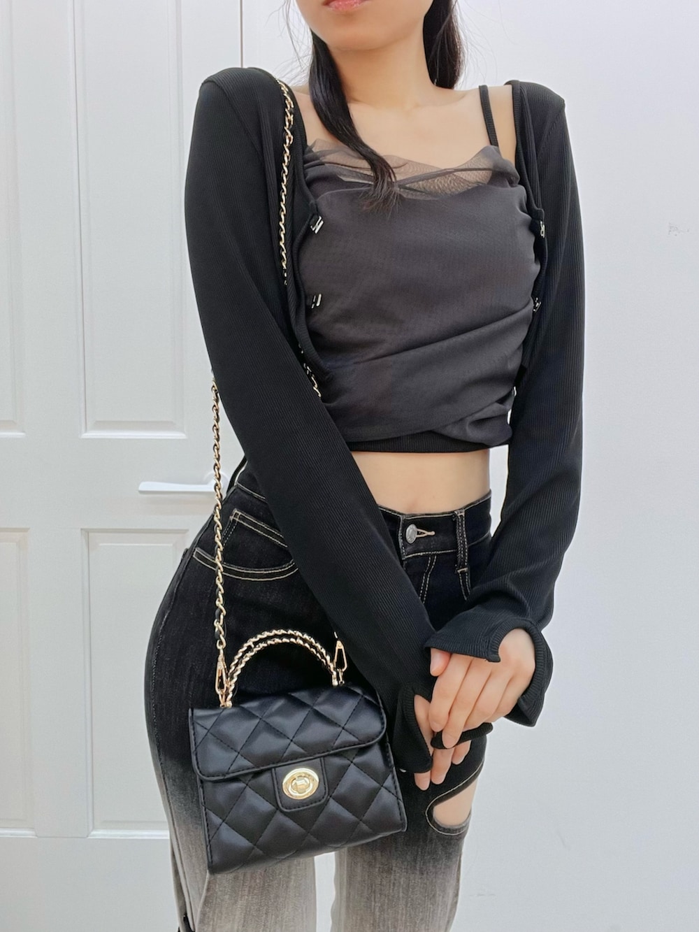 その他のデニムパンツ、ブラック系のブーツ、ブラック系のハンドバッグを着用したレディースの冬コーディネートの5枚目の写真