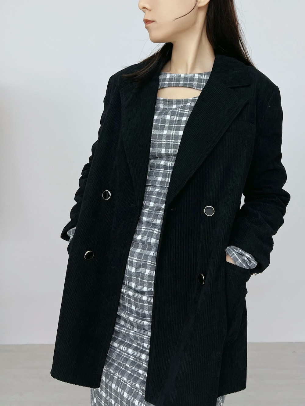 グレー系のワンピース、ブラック系のテーラードジャケット、ブラック系のブーツを着用したレディースの秋コーディネートの5枚目の写真