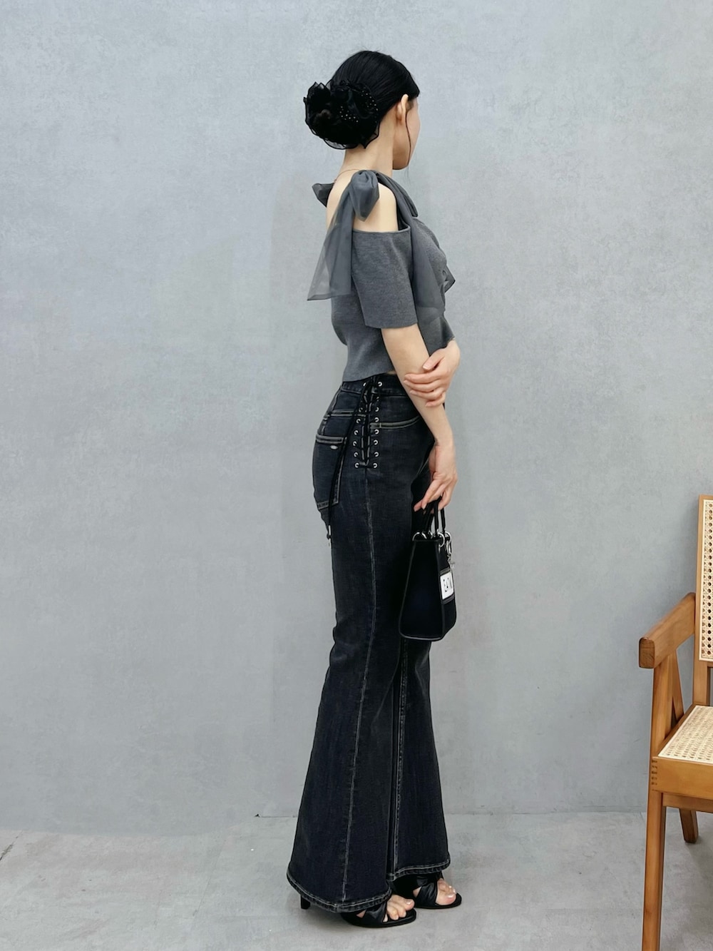 ブルー系のデニムパンツ、ブラック系のショルダーバッグ、グレー系のTシャツ/カットソーを着用したレディースの春コーディネートの2枚目の写真