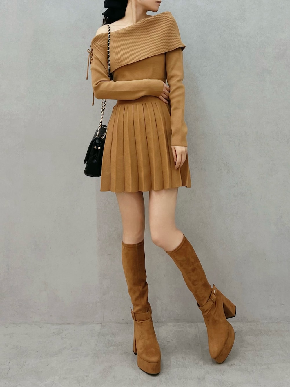 ブラウン系のワンピース、ブラウン系のブーツ、ブラック系のハンドバッグを着用したレディースの秋コーディネートの4枚目の写真