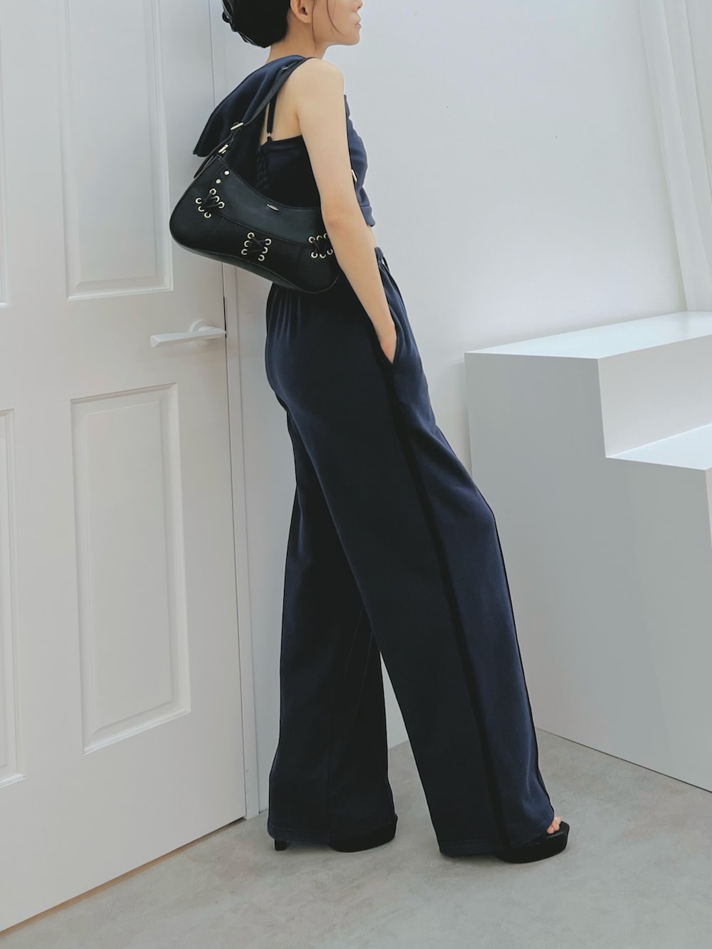 ブルー系のスウェットパンツ、ブルー系のキャミソール、ブラック系のショルダーバッグを着用したレディースの秋コーディネートの3枚目の写真