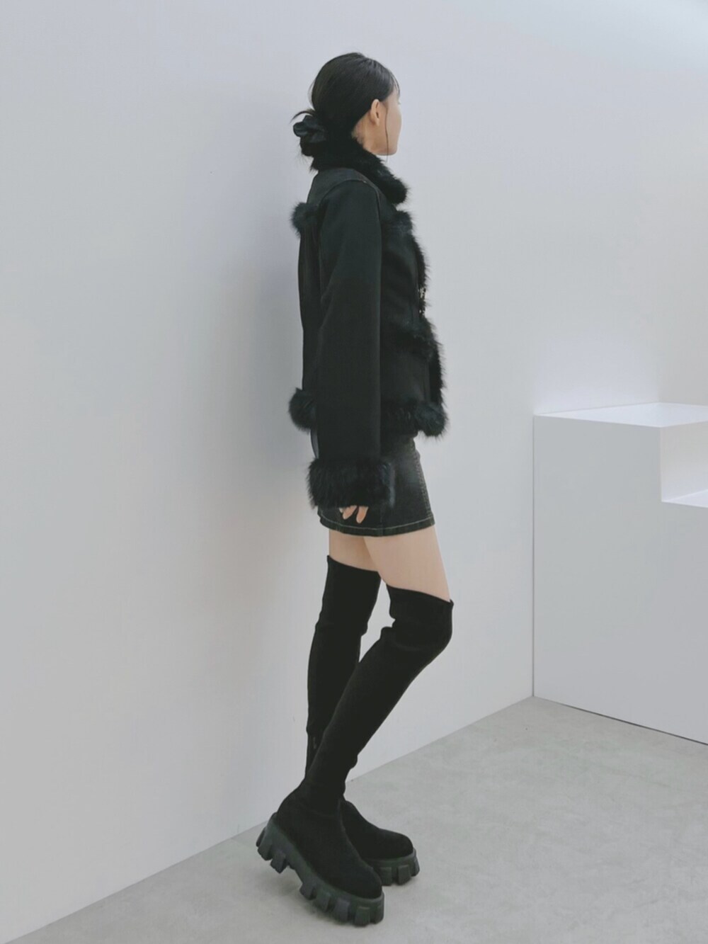 ブラック系のデニムスカート、ブラック系のブーツ、ブラック系のブルゾンを着用したレディースの秋コーディネートの3枚目の写真