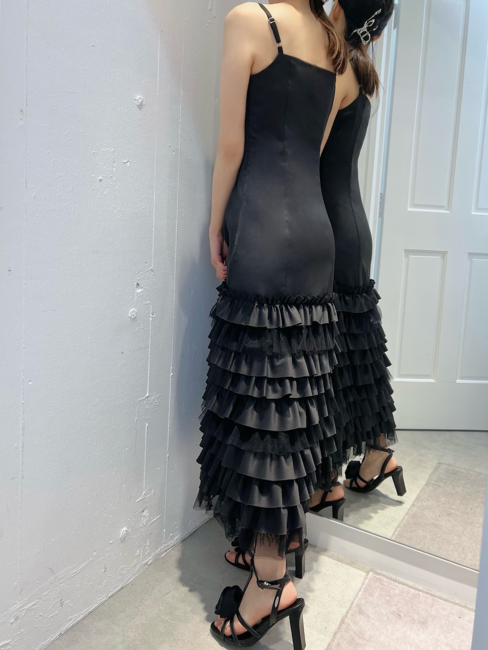 ブラック系のワンピース、ブラック系のサンダルを着用したレディースの冬コーディネートの2枚目の写真