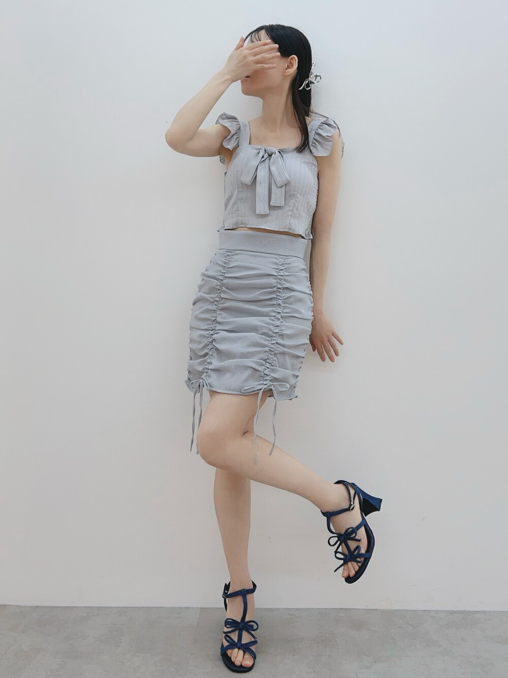 グレー系のシャツ/ブラウス、ブルー系のスカート、ブルー系のサンダルを着用したレディースの春コーディネートの2枚目の写真