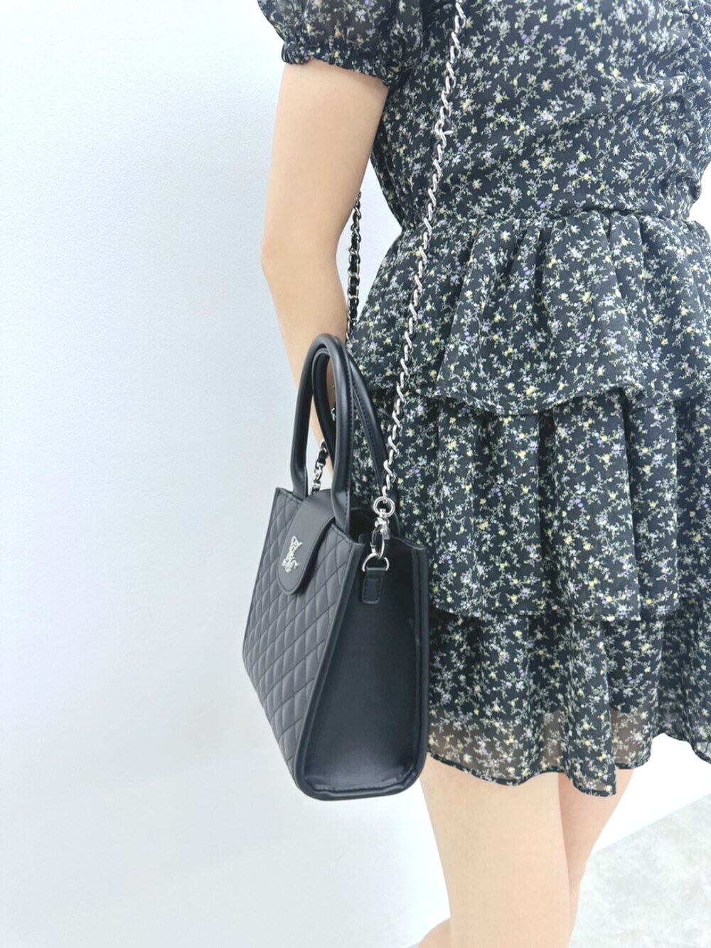 ブラック系のハンドバッグ、ブラック系のサンダル、ブラック系のワンピースを着用したレディースの夏コーディネートの7枚目の写真