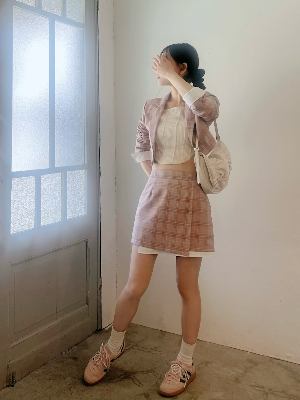 ピンク系のスカート、ホワイト系のショルダーバッグ、ピンク系のテーラードジャケットを着用したレディースの春コーディネートの3枚目の写真