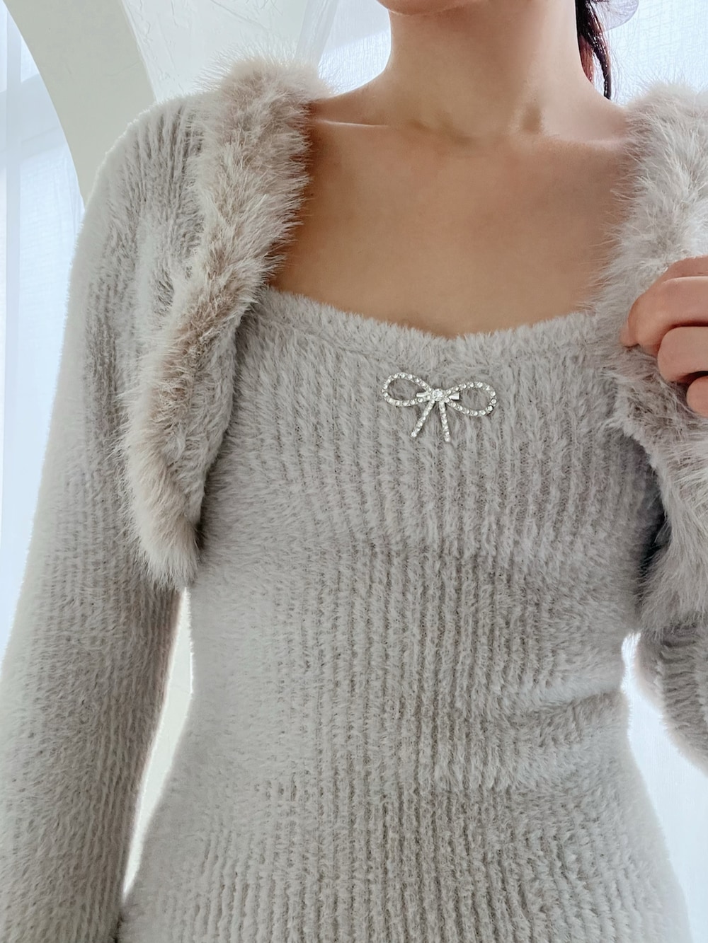 グレー系のワンピース、ホワイト系のブーツを着用したレディースの冬コーディネートの5枚目の写真