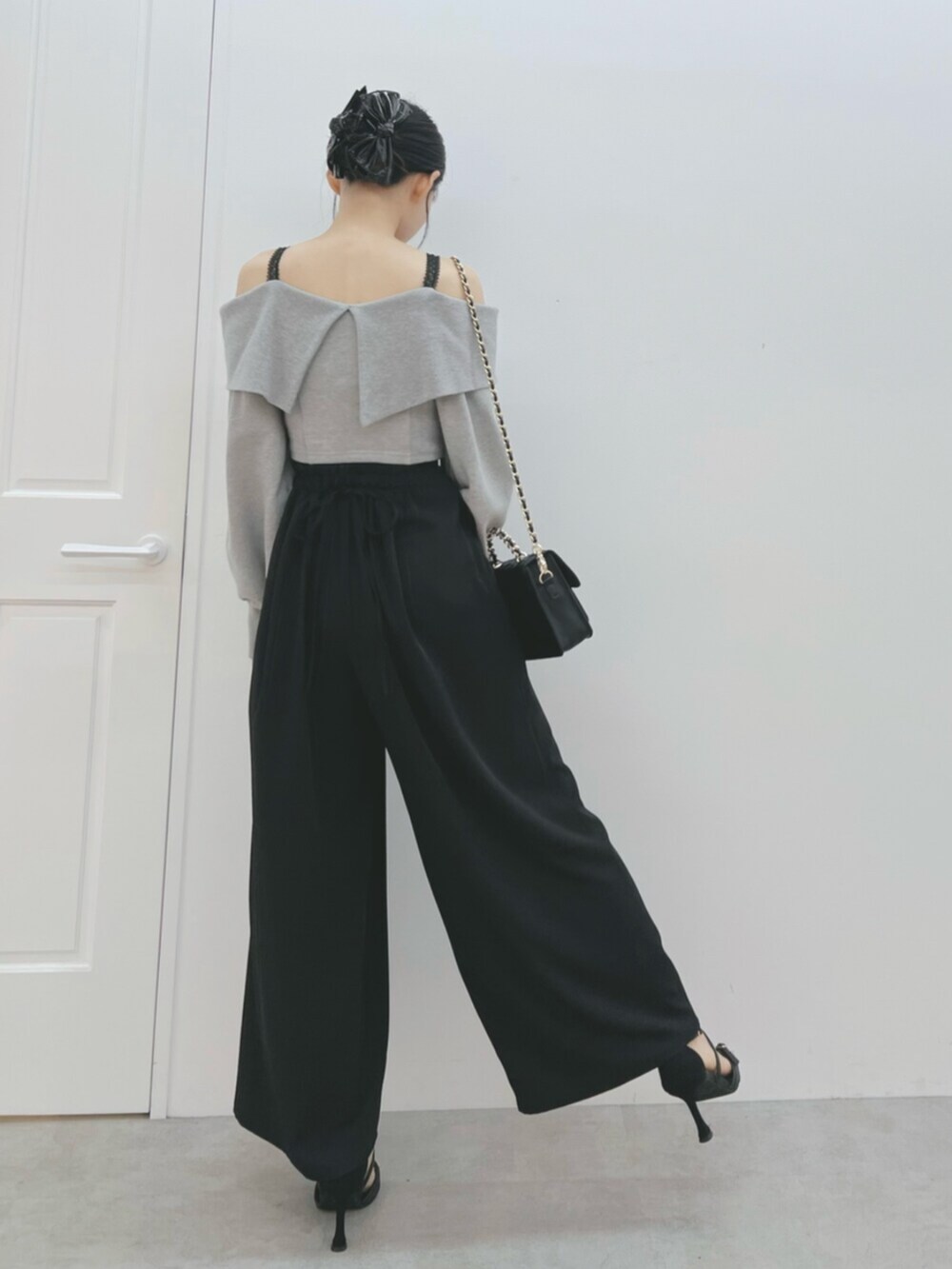 ブラック系のショルダーバッグ、ブラック系のサンダル、グレー系のTシャツ/カットソーを着用したレディースの夏コーディネートの4枚目の写真