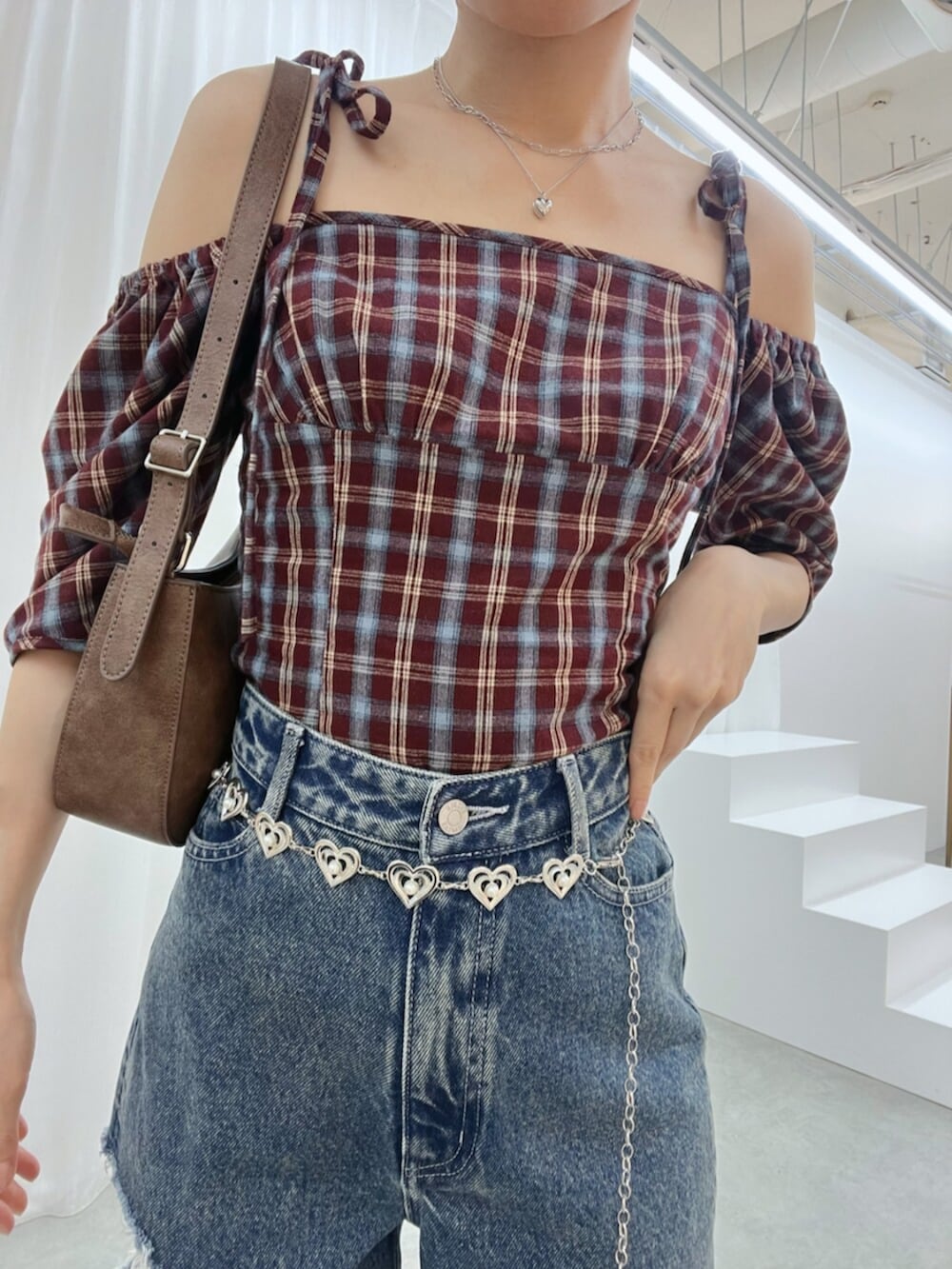 ブラウン系のショルダーバッグ、ブルー系のデニムパンツ、ブラウン系のサンダルを着用したレディースの秋コーディネートの7枚目の写真