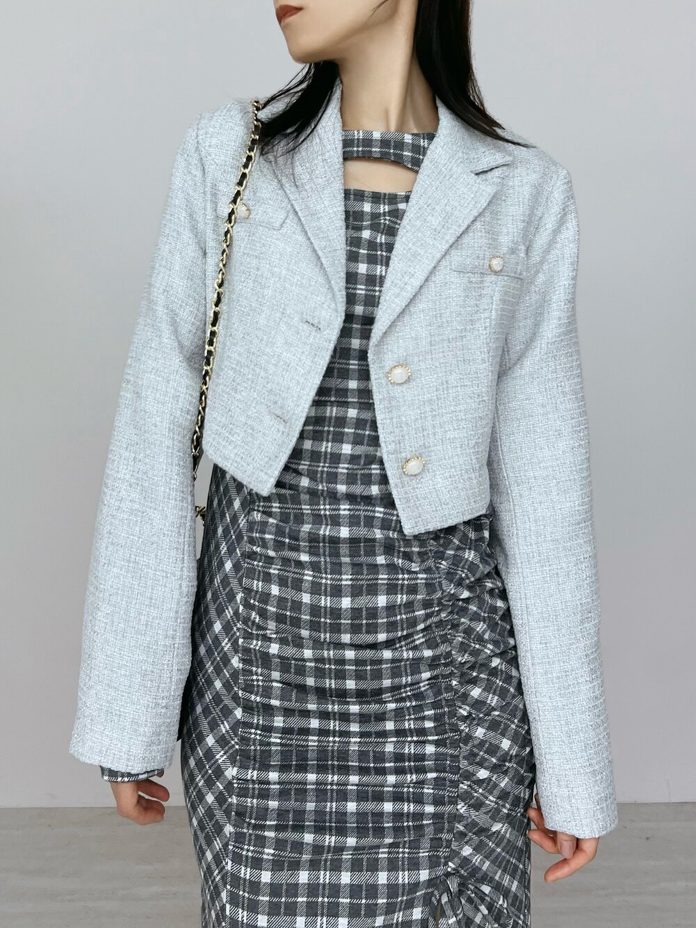 グレー系のワンピース、ブラック系のブーツ、グレー系のテーラードジャケットを着用したレディースの秋コーディネートの6枚目の写真