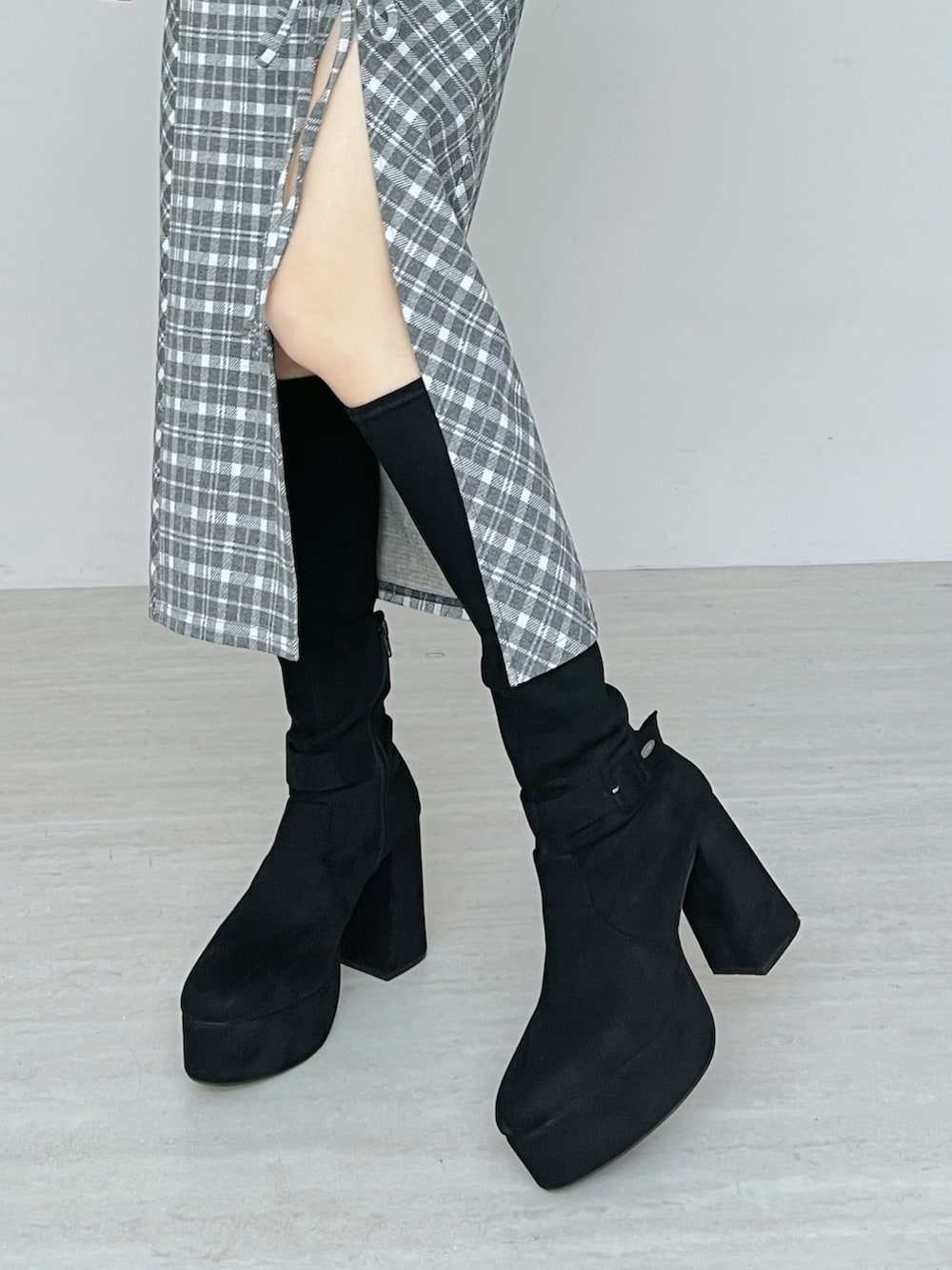 グレー系のワンピース、ブラック系のテーラードジャケット、ブラック系のブーツを着用したレディースの秋コーディネートの6枚目の写真