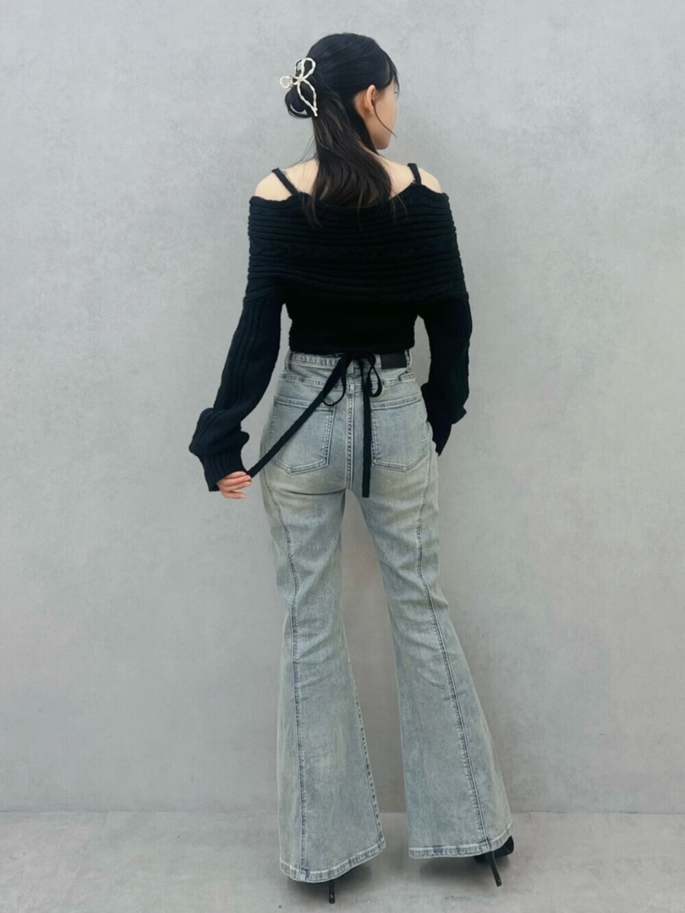 ブラック系のブーツ、ブルー系のデニムパンツ、ブラック系のニット/セーターを着用したレディースの冬コーディネートの3枚目の写真