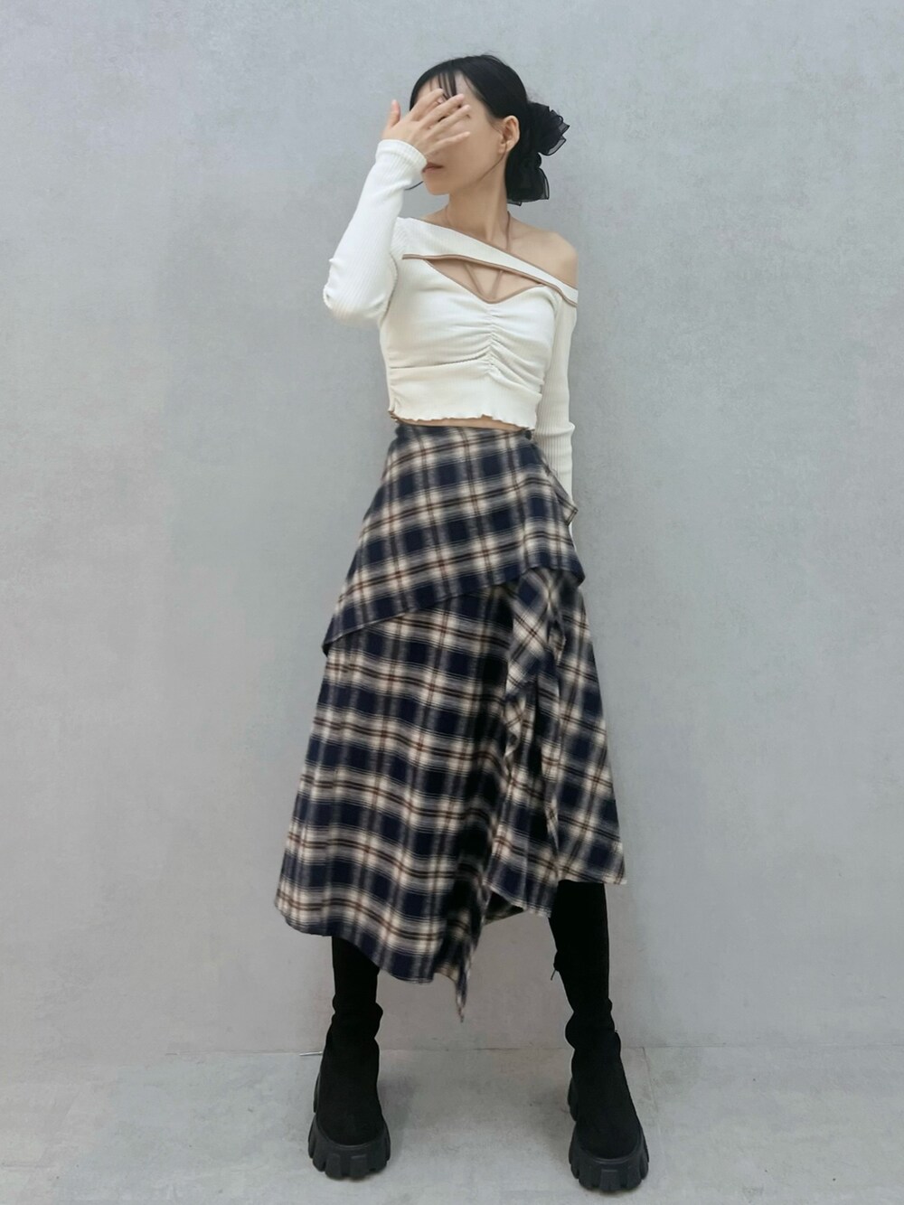 ブルー系のスカート、ホワイト系のTシャツ/カットソー、ブラック系のブーツを着用したレディースの秋コーディネートの4枚目の写真