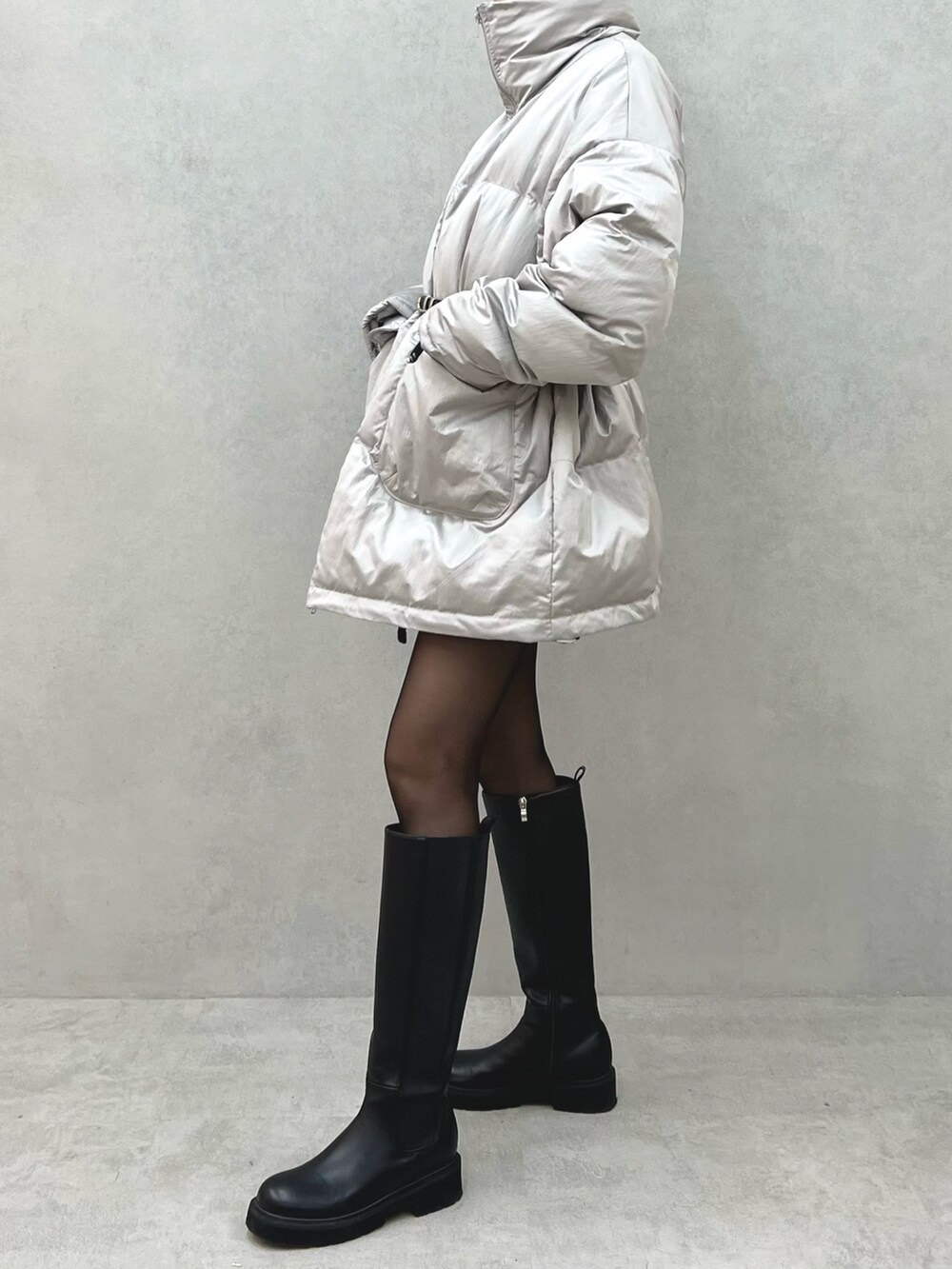 グレー系のブルゾン、ブラック系のハンドバッグ、ブラック系のベルトを着用したレディースの冬コーディネートの3枚目の写真