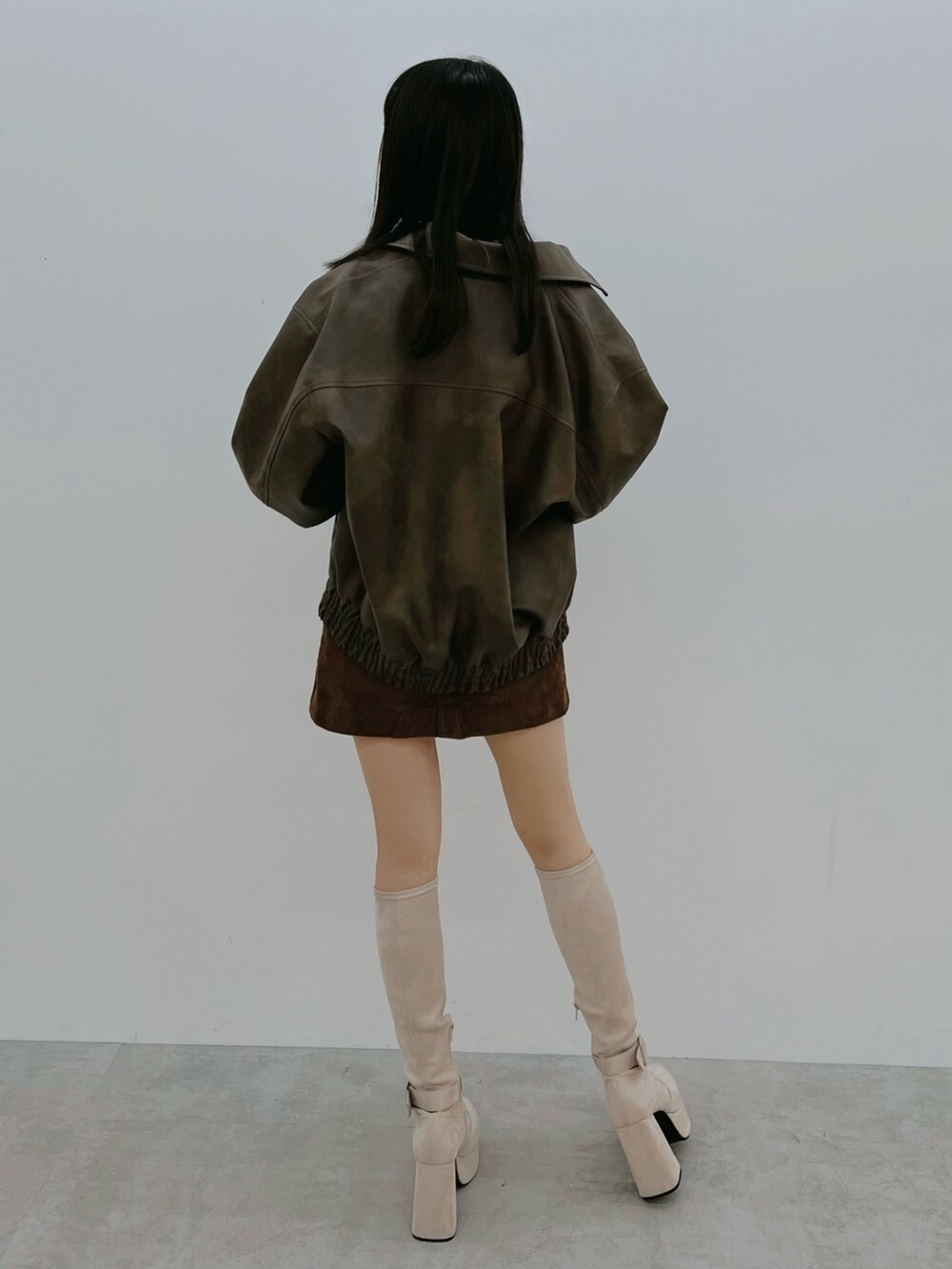 ブラウン系のブルゾン、ホワイト系のブーツを着用したレディースの秋コーディネートの5枚目の写真