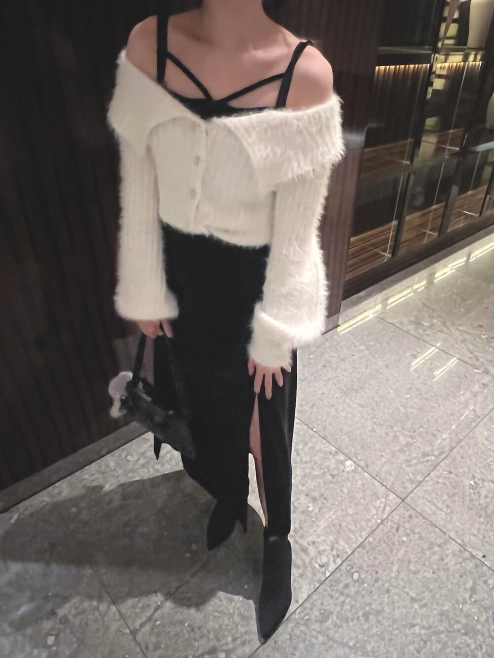 ブラック系のワンピース、ホワイト系のニット/セーターを着用したレディースの冬コーディネートの3枚目の写真