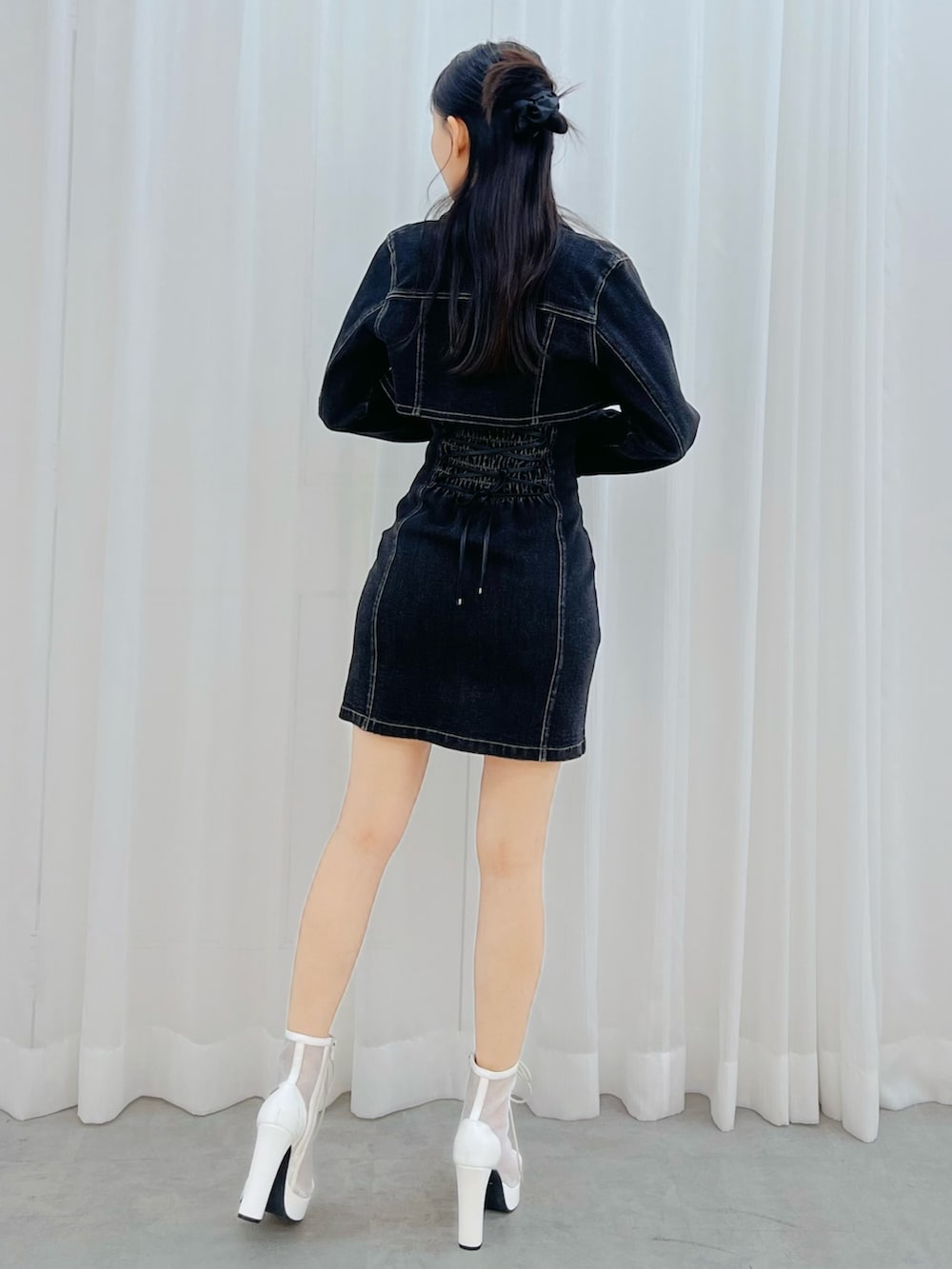 ブラック系のワンピース、ホワイト系のブーツを着用したレディースの冬コーディネートの3枚目の写真