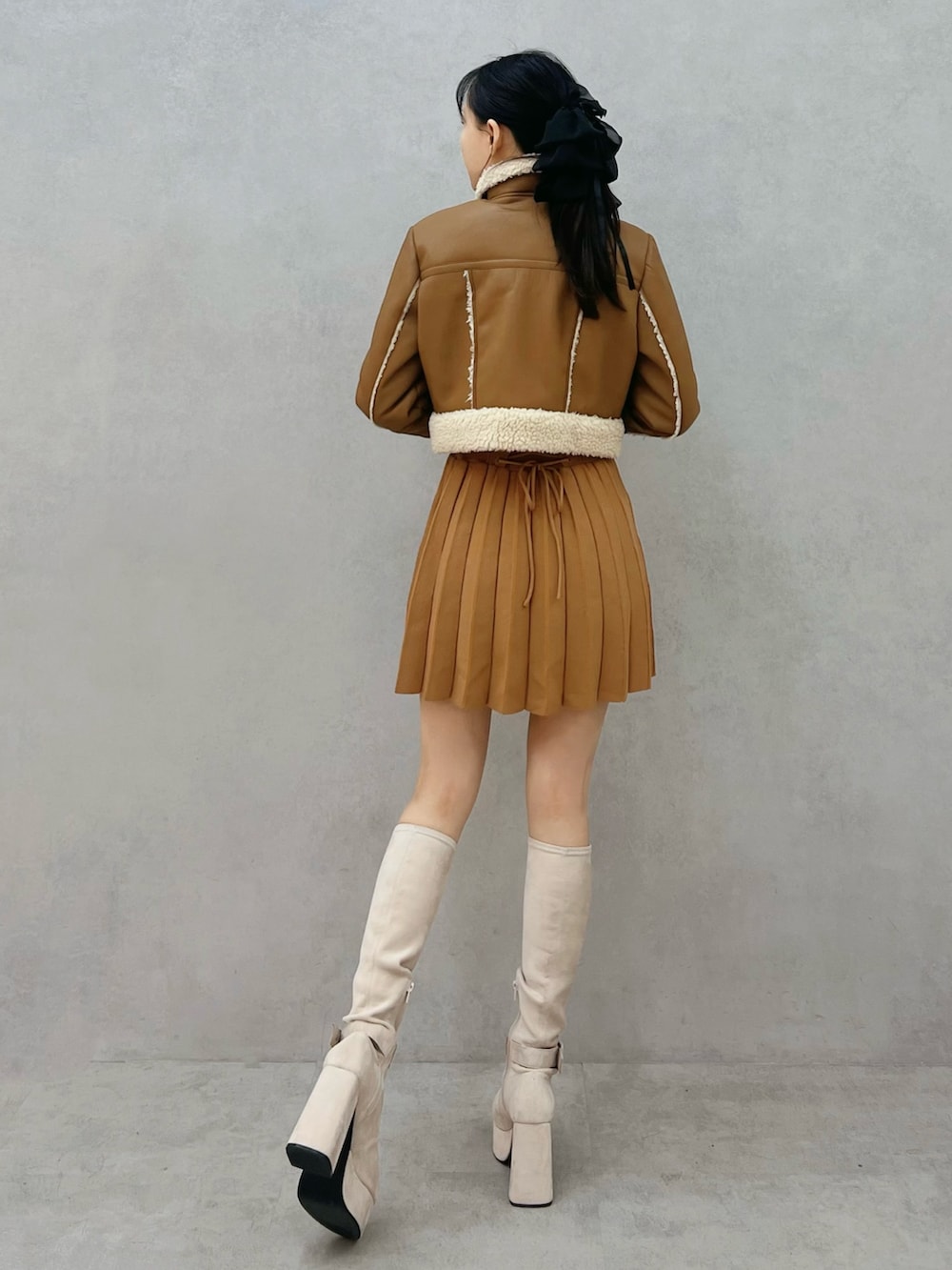 ブラウン系のワンピース、ブラウン系のワンピース、ホワイト系のブーツを着用したレディースの秋コーディネートの3枚目の写真