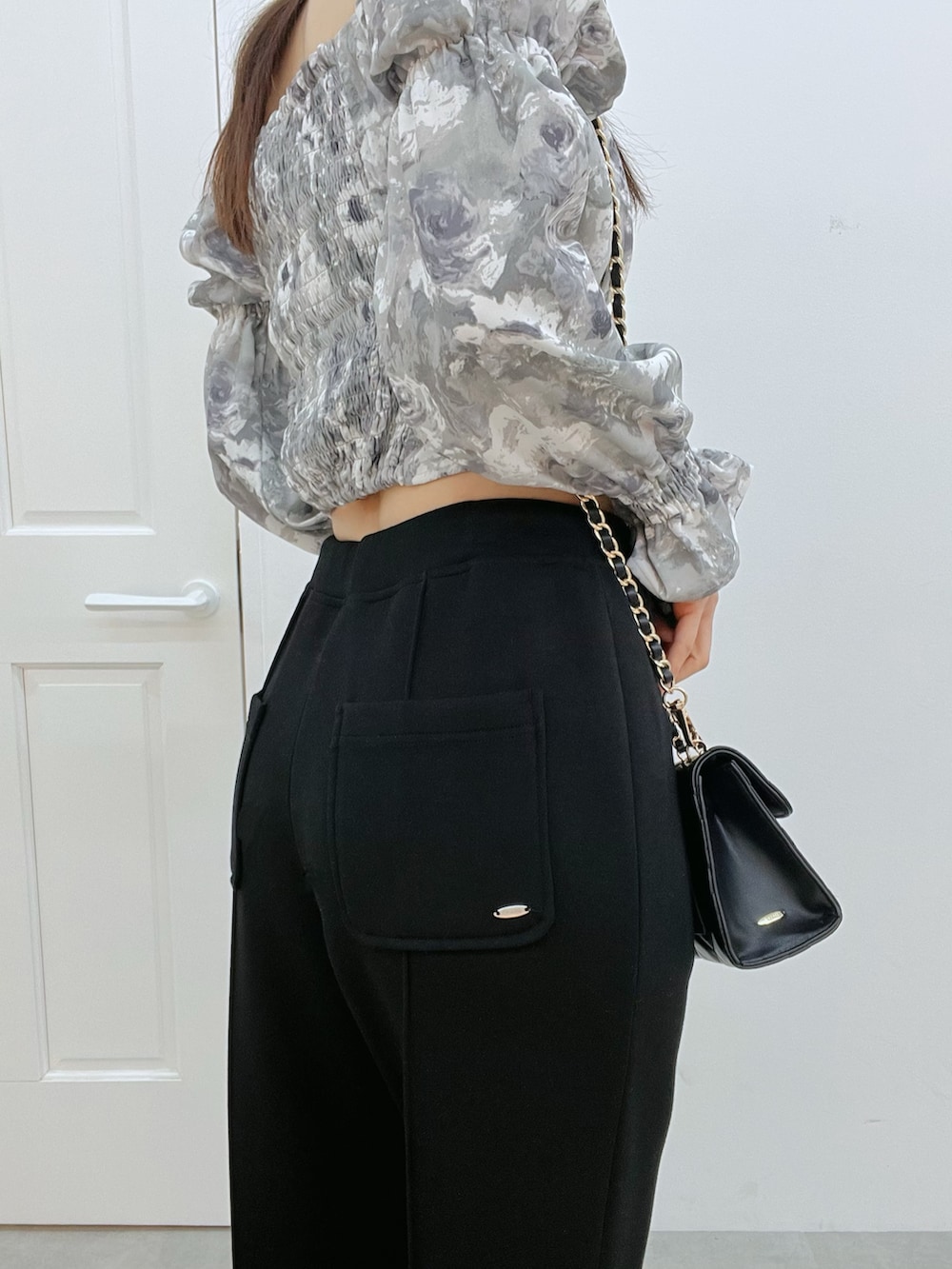 グレー系のシャツ/ブラウス、ブラック系のその他パンツ、ブラック系のハンドバッグを着用したレディースの冬コーディネートの7枚目の写真