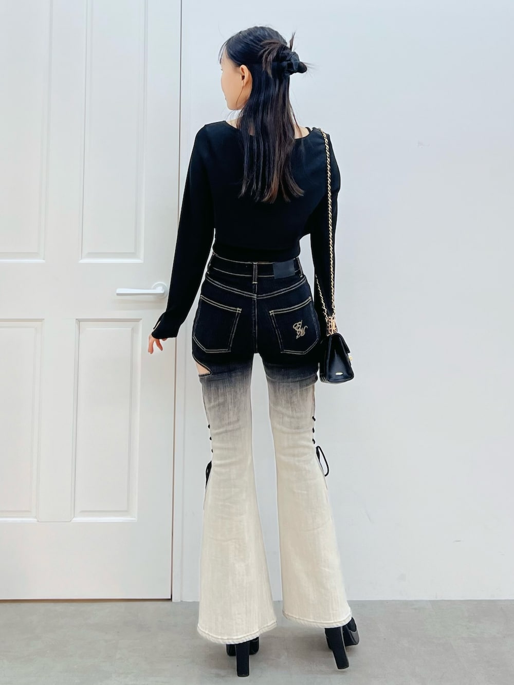 その他のデニムパンツ、ブラック系のブーツ、ブラック系のハンドバッグを着用したレディースの冬コーディネートの3枚目の写真