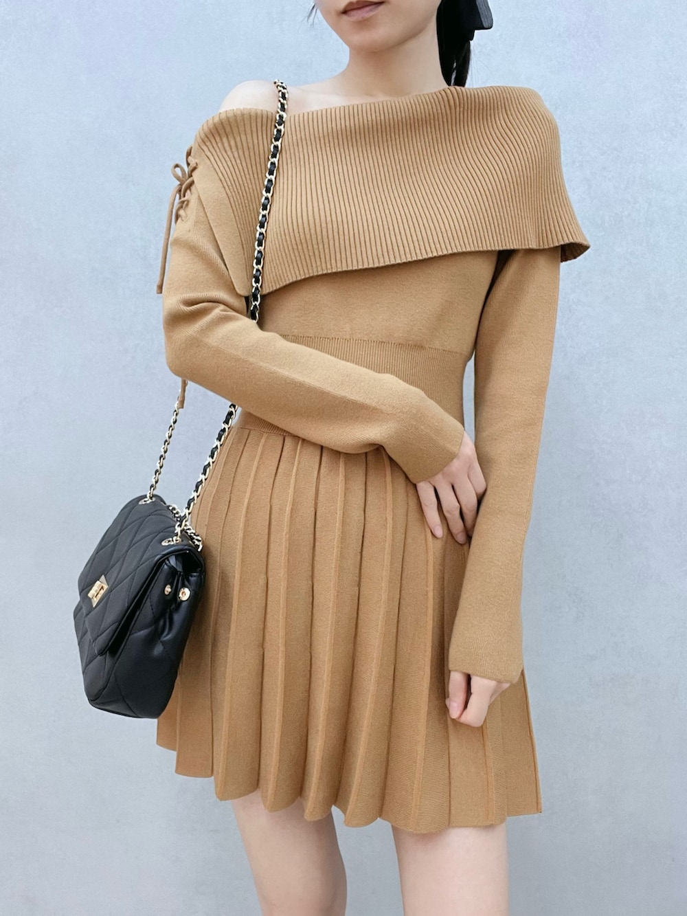 ブラウン系のワンピース、ブラウン系のブーツ、ブラック系のハンドバッグを着用したレディースの秋コーディネートの6枚目の写真