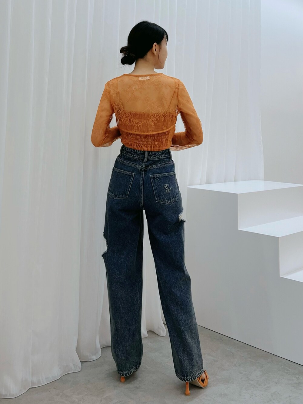 ブルー系のデニムパンツ、オレンジ系のシャツ/ブラウス、オレンジ系のサンダルを着用したレディースの秋コーディネートの3枚目の写真