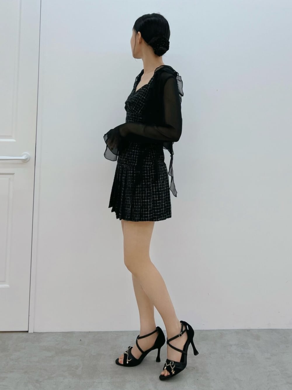 ブラック系のワンピース、ブラック系のサンダル、ブラック系のカーディガン/ボレロを着用したレディースの夏コーディネートの2枚目の写真