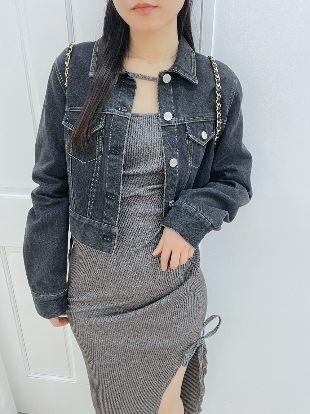 グレー系のワンピース、ブラック系のブーツ、ブラック系のデニムジャケットを着用したレディースの春コーディネートの5枚目の写真