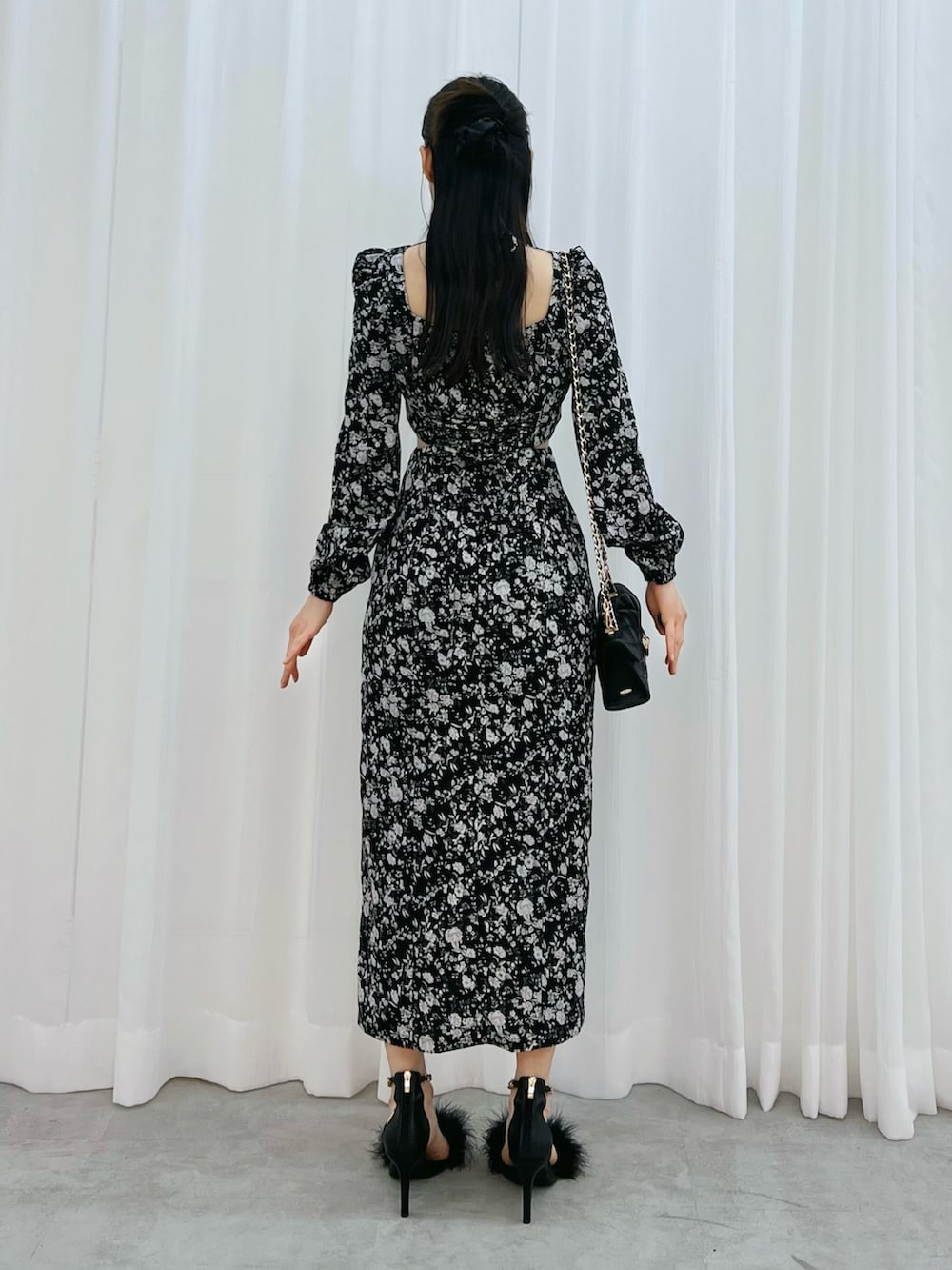 ブラック系のワンピース、ブラック系のサンダル、ブラック系のハンドバッグを着用したレディースの冬コーディネートの3枚目の写真