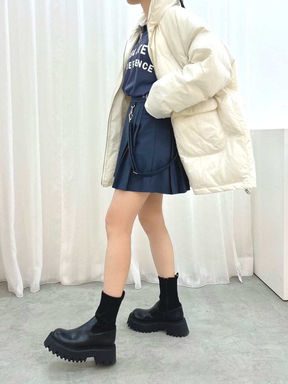 ブルー系のスカート、ホワイト系のブルゾン、ブルー系のTシャツ/カットソーを着用したレディースの冬コーディネートの4枚目の写真