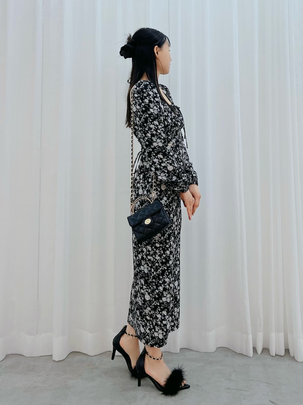 ブラック系のワンピース、ブラック系のサンダル、ブラック系のハンドバッグを着用したレディースの冬コーディネートの2枚目の写真